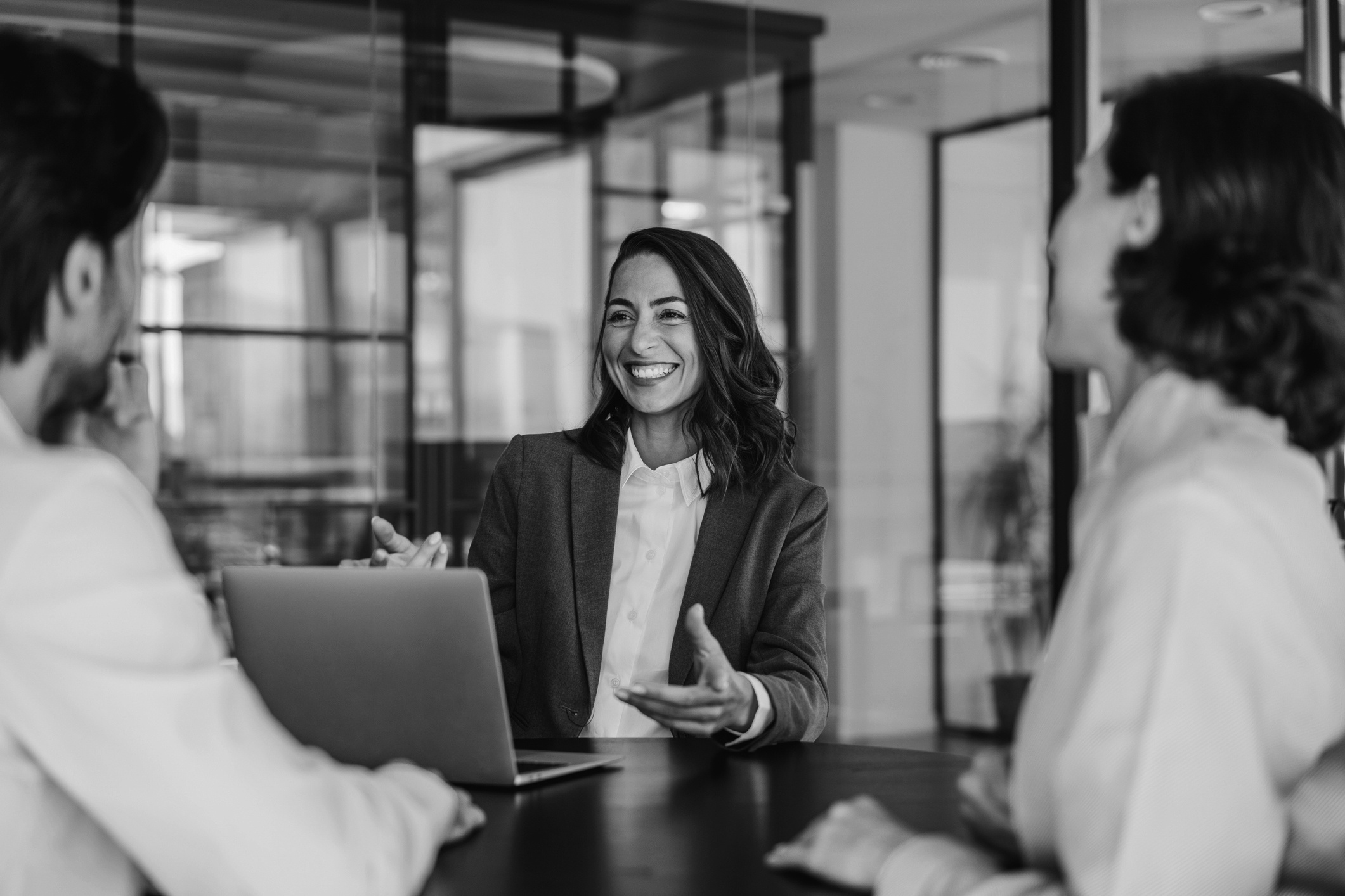 Smiling professional talking with two colleagues at a meeting table